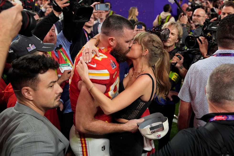 FILE - Kansas City Chiefs tight end Travis Kelce (87) kisses Taylor Swift after the Kansas...